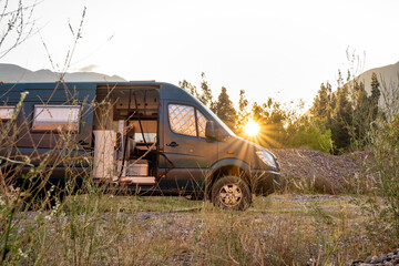 Canvas Print - Campervan 4x4 seen from the side with the sun behind it