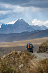 Canvas Print -  green campervan with a high, snow-capped mountain range