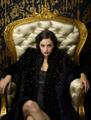 An elegant, attractive woman sitting on a throne, radiating a bossy and assertive look