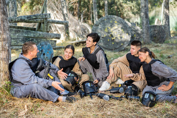 Canvas Print - Team of paintball players discussing the past game