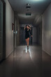 © Svetlana Radayeva - A young scared woman in a panic runs away along a dark corridor.