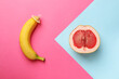 Banana with condom and half of grapefruit on color background, flat lay. Safe sex concept