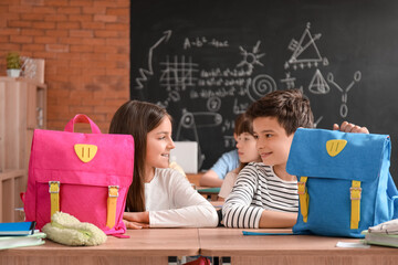 Poster - Little pupils with backpacks sitting in classroom