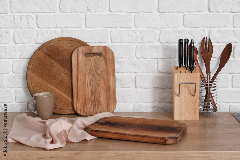 Wooden kitchen counter with cutting boards, cup and utensils