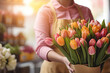 Close-up of a woman florist holding the bouquet of tulips in the retail flowers store