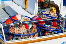 Pile Of Crab Fishing Nets And Red Buoys On A Boat