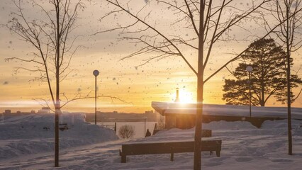 Wall Mural - 4K Beautiful snowy white city park on a frosty winter day. There is snow in the winter. Winter park, hyperlapse camera movement, time lapse. Snowy weather. Sunset Sunrise Sun in sunny winter in snowy