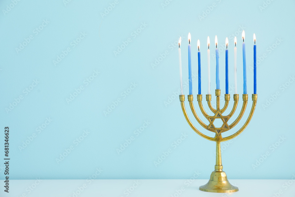 Menorah with burning candles on table in living room, closeup. Hanukkah celebration