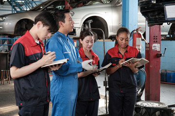 Specialist lecture. Male supervisor engineer describe automotive suspension fixing with mechanic worker staff teams for repair work at car service garage and maintenance jobs in automobile industry.