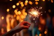 © Azra - close up of person hands with sparkler burning bangel agianst bookeh lights new year celebration background