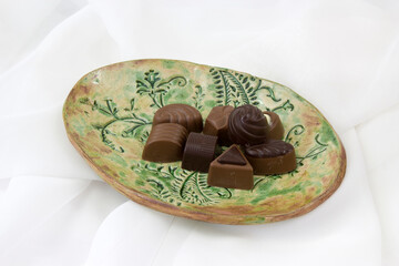 Poster - a lot of variety chocolate pralines on a clay plate