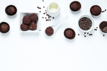 Wall Mural - Brigadeiro and chocolate chips in bowls on white background, space for text