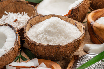 Wall Mural - Fresh opened coconuts along with coconut slices, flakes and coconut leaves on a wooden table.