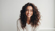 Portrait of a beautiful young woman with long curly hair smiling.