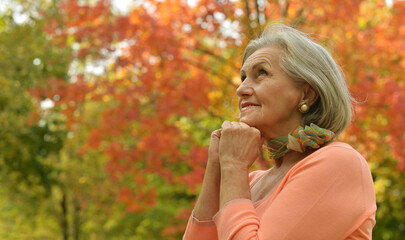 Wall Mural - Portrait of senior woman walking in autumn park