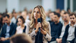 Female manager asking question from audience during business conference