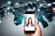 © ismael - Smartphone screen displaying a businesswoman on a global network connection background.IA generativa