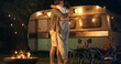 Young Couple Hugging and Kissing Outdoors in a Camping Area with Caravans in the Evening After Boyfriend Making a Wedding proposal. Loving Partners Enjoy Spending Time and Traveling Together.