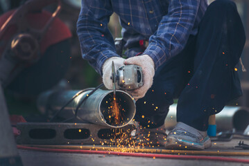 Wall Mural - Locksmith use Welding machine cut metal process. Construction Worker hands using Welding machinery iron metal sparking. Men hands wear protective glove Hot flame metal work cutting fire iron workshop