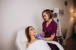 © Roman - Professional female beautician makes a rejuvenating injection to a young woman who lies relaxed with her eyes closed in a modern beauty salon. Concept of smoothing wrinkles with injections.