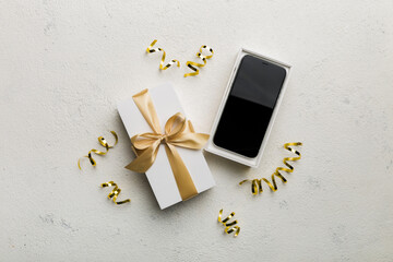 Wall Mural - Opened gift box with gold ribbon and smartphone on color background, top view. Blank open box packaging mockup , Template for your design - branding mockup