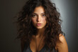 © Synthetica - Portrait of beautiful young woman with long curly hair on grey background.