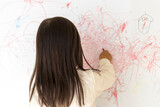 Fototapeta  - 壁のホワイトボードに落書きする女の子の後ろ姿（3歳、日本人）
