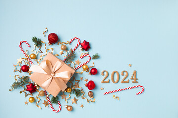 Wall Mural - Gift or present box with 2024 numbers and Christmas decorations on blue background top view. Flat lay.