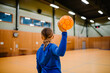© Johnér - Rear view of girl holding handball in sports court