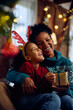 Leinwandbild Motiv Cheerful black mother and daughter on Christmas day at home.