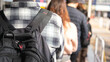 © Nattawit - Close-up at back of a man with backpack bag during queue up and waiting to buy a attractive event ticket, with blurred background of many people in queue.