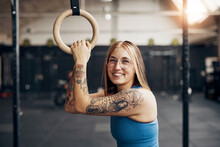 Fit woman holding a ring and smiling during a gym workout