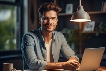 Poster - Young business man happily working at home with laptop and papers on desk.