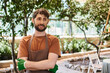 © LIGHTFIELD STUDIOS - professional headshots, cheerful bearded gardener in apron and gloves posing in greenhouse