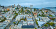 San Francisco apartment buildings aerial wide view of city streets with Golden Gate Bridge in distance, CA