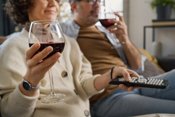 Poster - Couple drinking red wine and watching TV while resting on sofa in the living room