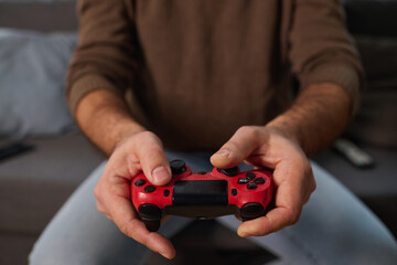 Poster - Close-up of man with joystick playing video game while sitting on sofa in the room