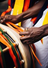 Drummer At A Caribbean Carnival, Rhythmically Beating A Steel Drum Adorned With Bright Ribbons