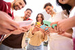 © CarlosBarquero - Group of young people in circle using cell phones together outdoor. Cheerful friends meeting looking at colorful mobiles enjoying fun content on social networks. Generation z, addiction to technology