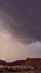 Wall Mural - Vertical Monsoon storm moving through the Utah desert in timelapse over the cliffs at Capitol Reef.