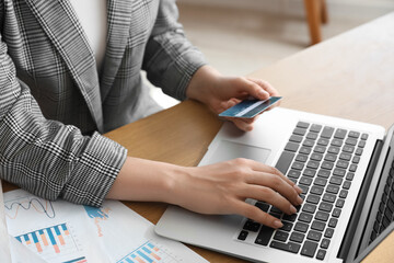 Sticker - Young businesswoman with credit card using laptop at table in office, closeup