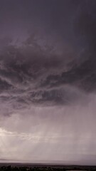 vertical dark clouds rotating in the sky in front of monsoon storm in utah moving through the desert