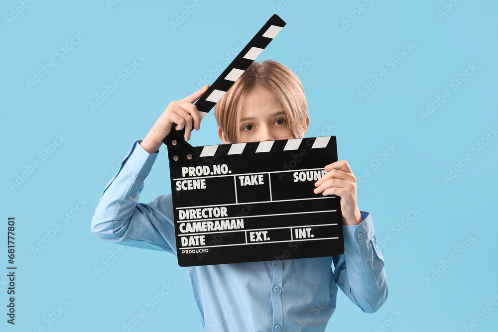 Little actor with movie clapper on blue background