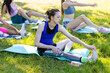 © ArtSys - Multiracial group of college friends sitting on a grass after workout. Young girl with bionic leg prosthesis. Concept of sport community, support, diversity, inclusion, multicultural friendship
