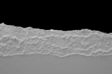 Wall Mural - edge of a torn white sheet of paper on a black background, black hole