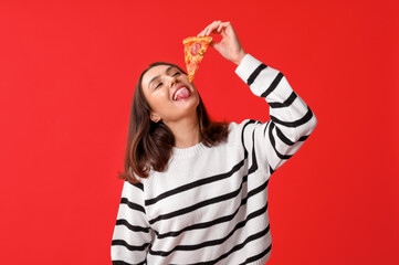 Poster - Young woman holding piece of tasty pizza on red background