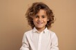 © Chacmool - Portrait of a smiling little girl in a white shirt on a brown background