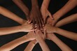 Group of multiracial people joining hands together on black background, closeup