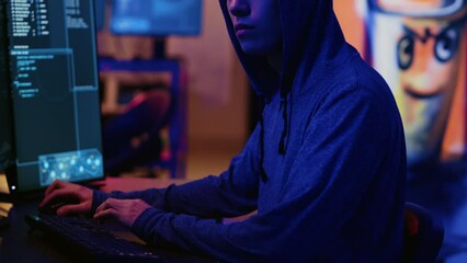 Asian hacker in dark hidden shelter trying to launch DDoS attack on website by sending large amounts of traffic from multiple sources to overwhelm it. Evil computer scientists flooding target server