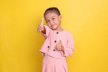 Adorable Asian little girl in pink dress showing thumbs up with happy expression